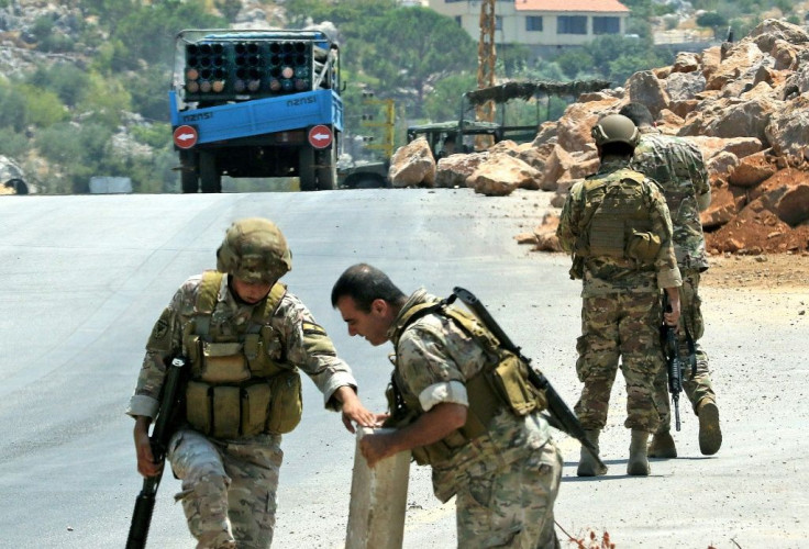 Lebanese soldiers stand next to a a truck carrying a multiple rocket launcher after confiscating it, in the southern village of Shouayya, on August 6, 2021