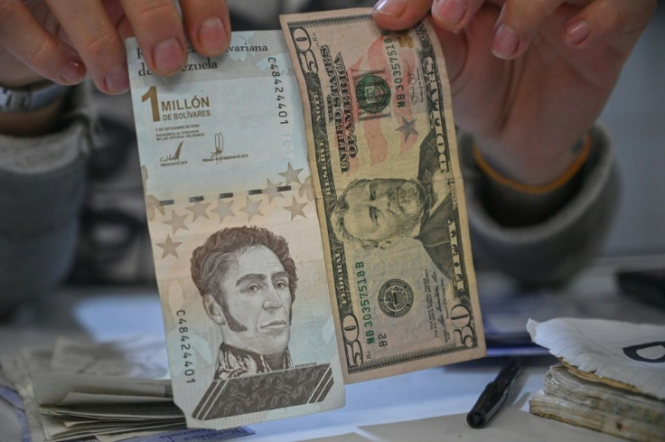 A man displays the one million bolivar banknote alongside a $50 one, which is worth about 200 times more