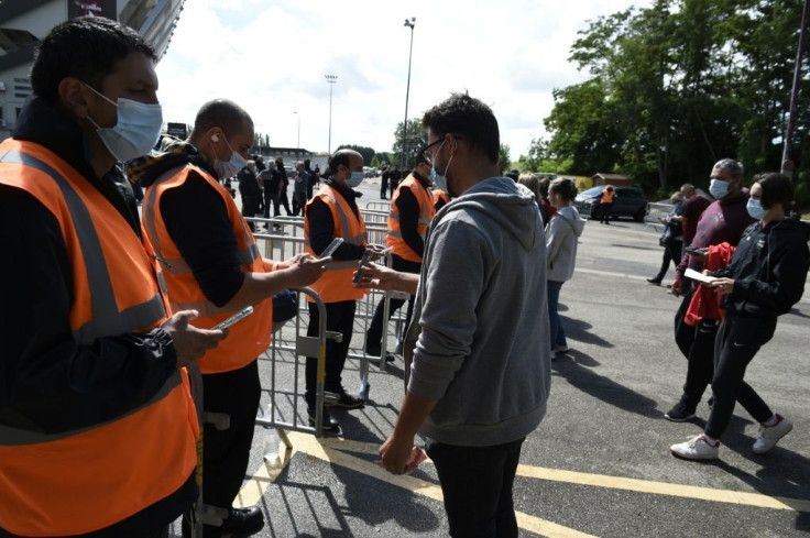 Stewards check supporters' health passes and tickets before the start of the French L1 football match between FC Metz and Lille OSC