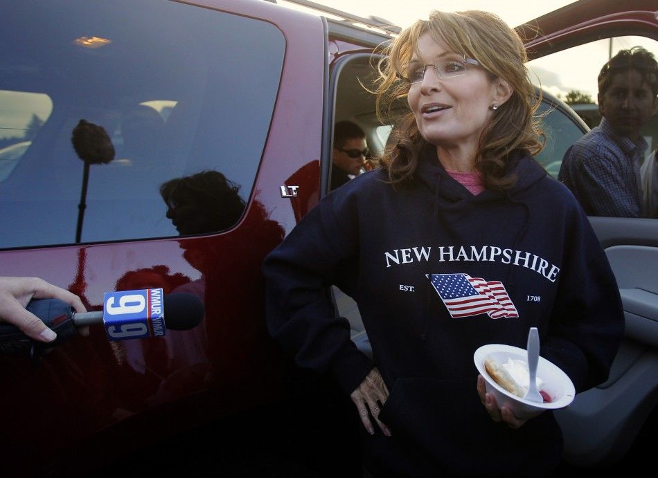 Former Alaska Governor Sarah Palin, wearing a New Hampshire sweatshirt, talks to reporters following a stop at a clam bake at a private residence in Seabrook