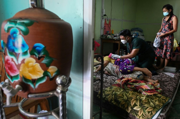 A volunteer treats a patient with Covid-19 at their home in Taungoo