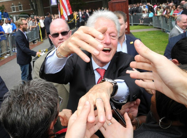 Former US president Bill Clinton(C) shakes hands with supporters in 2014