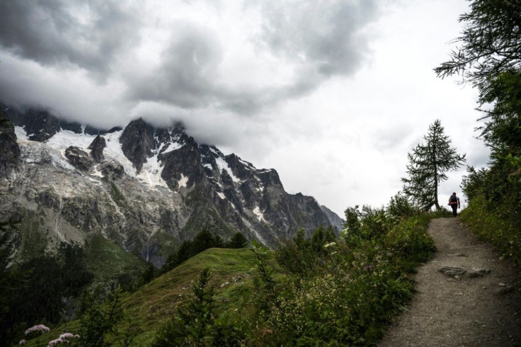 An hiker walks on a path near the Planpicieux (L) and Grand Jorasses Glaciers (2L) in Courmayeur