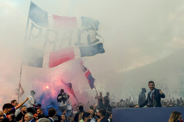 Paris Saint-Germain's Argentinian forward Lionel Messi salutes supporters gathered outside the Parc des Princes stadium