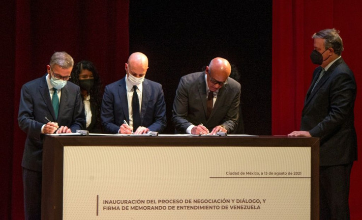 (From L to R) The head of the Venezuelan opposition delegation, Gerardo Blyde Perez; the director at the NOREF Norwegian Centre for Conflict Resolution, Dag Nylander; and the president of the Venezuelan National Assembly, Jorge Rodriguez, sign documents n
