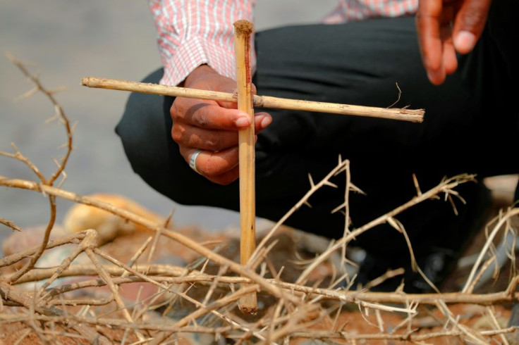 A Tigrayan refugee places a makeshift cross on the banks of the Setit River bordering Ethiopia