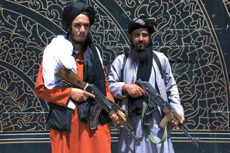 Taliban fighters stand guard in front of the provincial governor's office in Herat, where the insurgents issued amnesty letters to Afghan soldiers