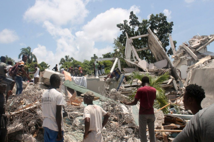People search through the rubble of what used to be the Manguier Hotel after the earthquake hit on August 14, 2021 in Les Cayes, southwest Haiti