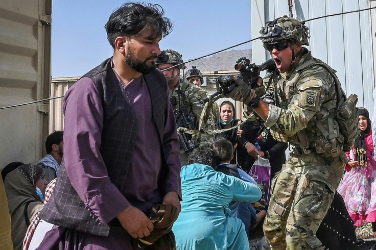 A US soldier points his gun towards an Afghan civilian as US forces secure the Kabul airport
