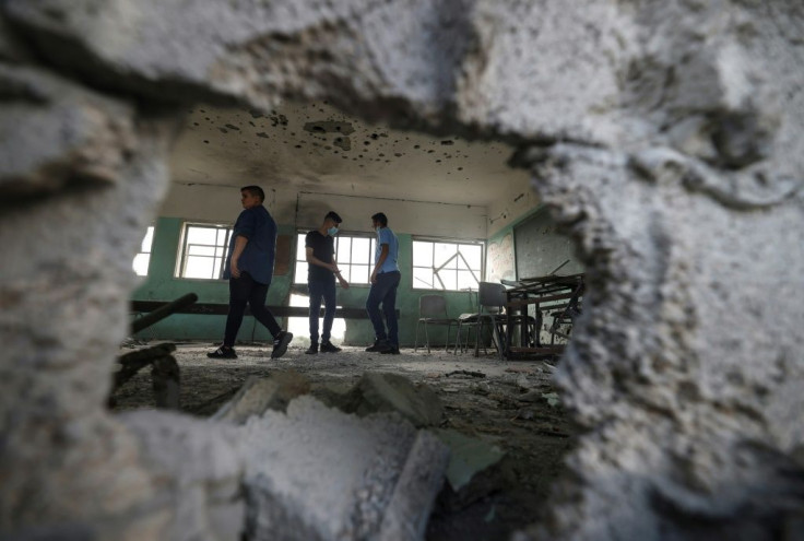 Palestinian students inspect a classroom at a school destroyed during the recent 11-day war between Israel and the Palestinian Hamas movement, on the first day of the new academic year in Gaza City, on August 16, 2021