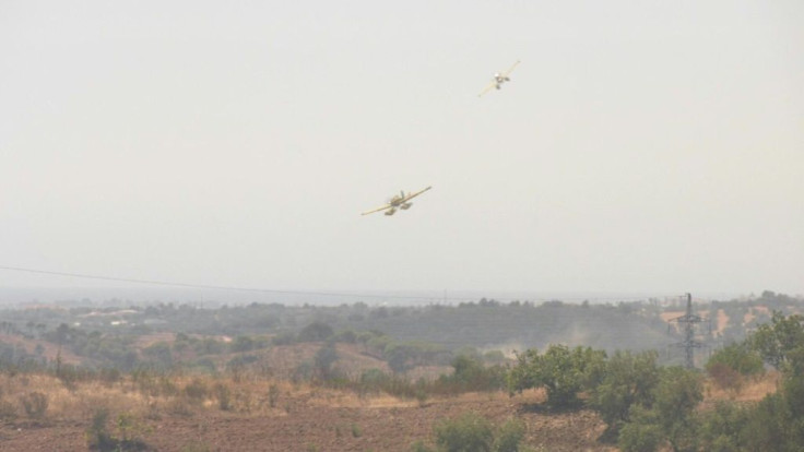 Firefighter aircraft drop water in an attempt to put out a blaze in Tavira in southern Portugal, the latest European nation to face extreme weather and fierce fires, which climate scientists warn are increasingly common with man-made global warming.