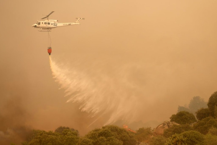 A helicopter drops water as fires rage in Navalmoral de la Sierra near Avila in central Spain on Monday.