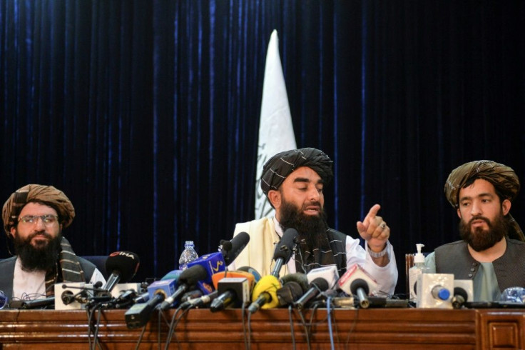 Taliban spokesman Zabihullah Mujahid (center) addresses the first press conference in Kabul following the Taliban's stunning takeover of Afghanistan