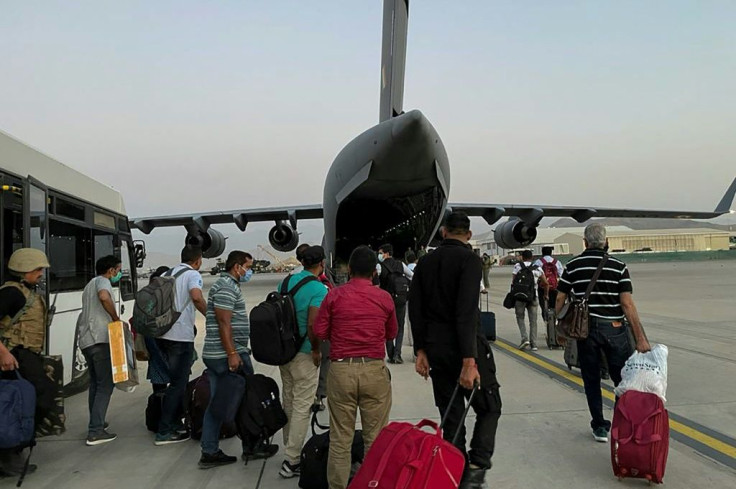 Indian Nationals prepare to board an Indian military aircraft at the airport in Kabul
