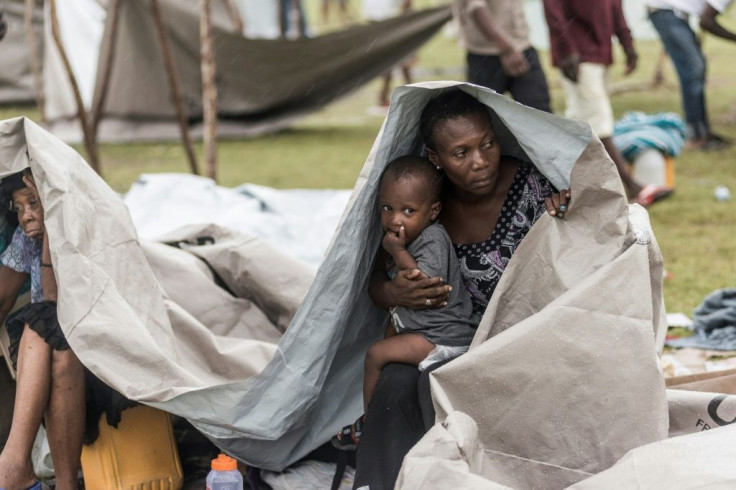 People gather after spending the night outside in the aftermath of the earthquake, facing the severe inclement weather of Tropical Storm Grace near Les Cayes, Haiti on August 17, 2021