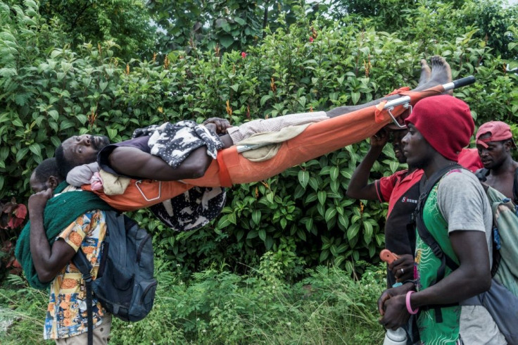 An injured man is carried to a health center after the earthquake in Camp-Perrin, Haiti on August 16, 2021