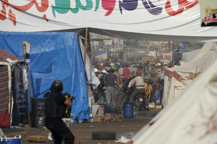 An Egyptian riot policeman points his gun towards protesters as security forces forcibly remove Islamist protesters from Cairo's Rabaa al-Adawiya square in August 2013
