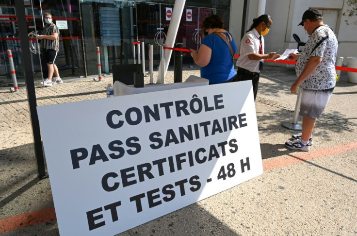 Visitors present health passes (pass sanitaire) to a security guard at the entrance of a movie theatre in Montpellier