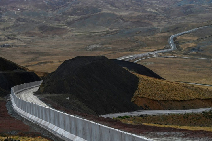 A concrete wall, topped with barbed wire and surrounded by trenches, is being erected along Turkey's border with Iran