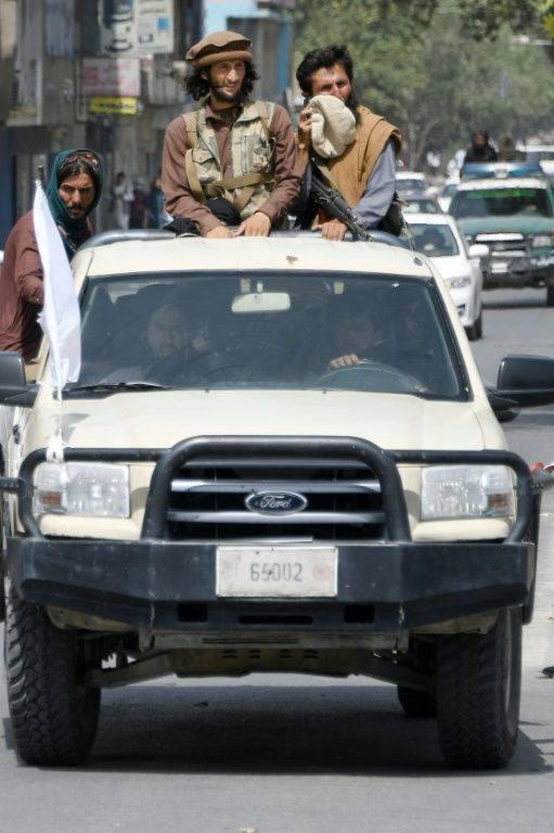 Taliban fighters patrol along a road in Kabul