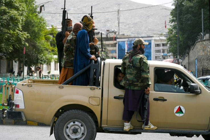 Taliban fighters patrol along a street in Kabul