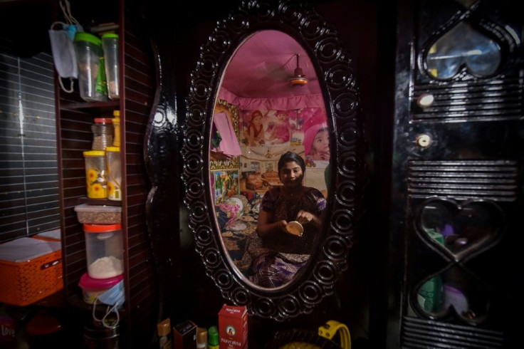 A sex worker puts on makeup while sitting in front of a mirror in Daulatdia
