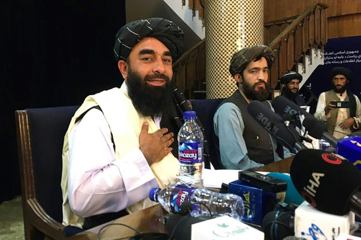 Taliban spokesman Zabihullah Mujahid (left) at a press conference in a building where the Afghan government used to brief media
