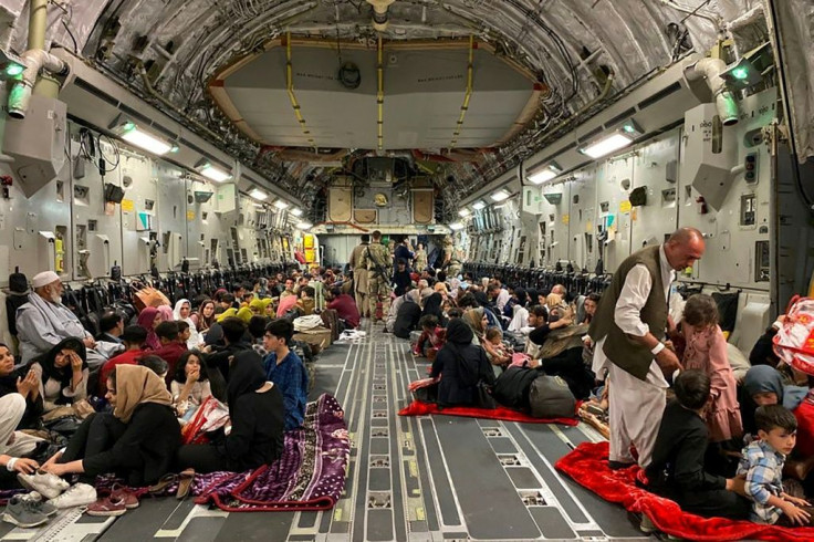 Afghans sit inside a US military aircraft as they prepare to leave Afghanistan at the military airport in Kabul
