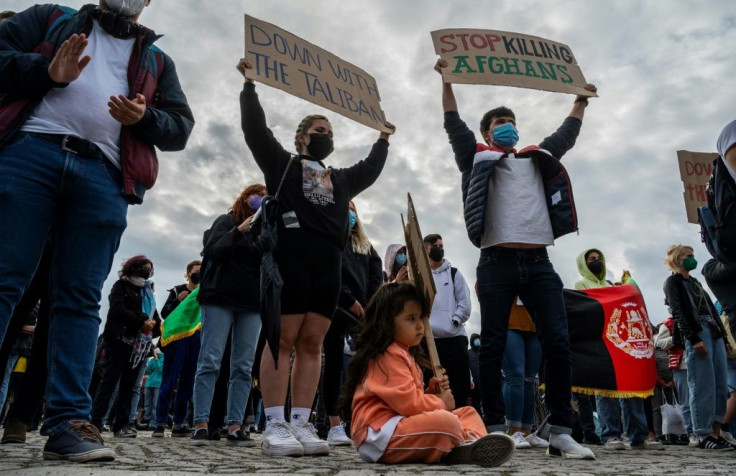 Demonstrators display placards in front of the Reichstag building in Berlin to demand safe passage for Afghans threatened by the Taliban
