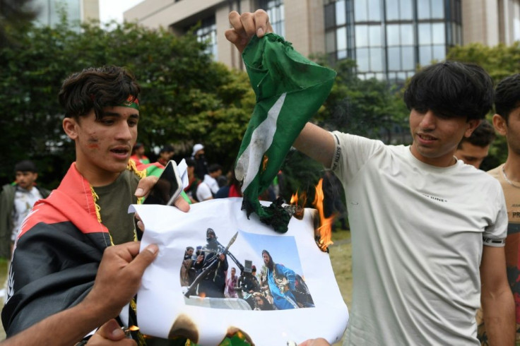 Afghan demonstrators in Brussels burn a flag of Pakistan as they protest the Taliban takeover of Afghanistan