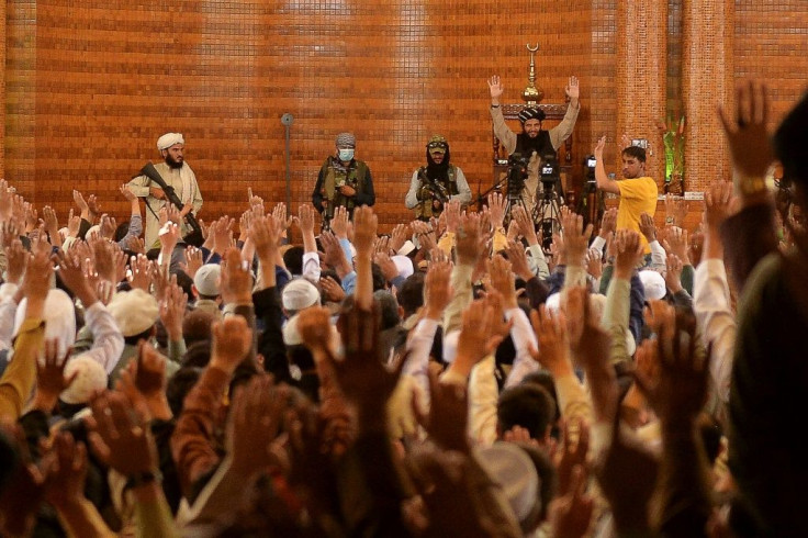 The gunmen flanking the scholar at Abdul Rahman mosque Friday cut imposing figures
