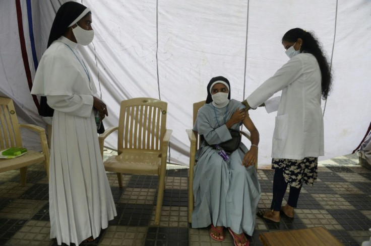 An Indian health worker inoculates a catholic nun with the Covishield vaccine -- one of six approved by New Delhi against Covid-19 -- at Saint Mary's Basilica in Secunderabad, the twin city of Hyderabad, on August 19, 2021