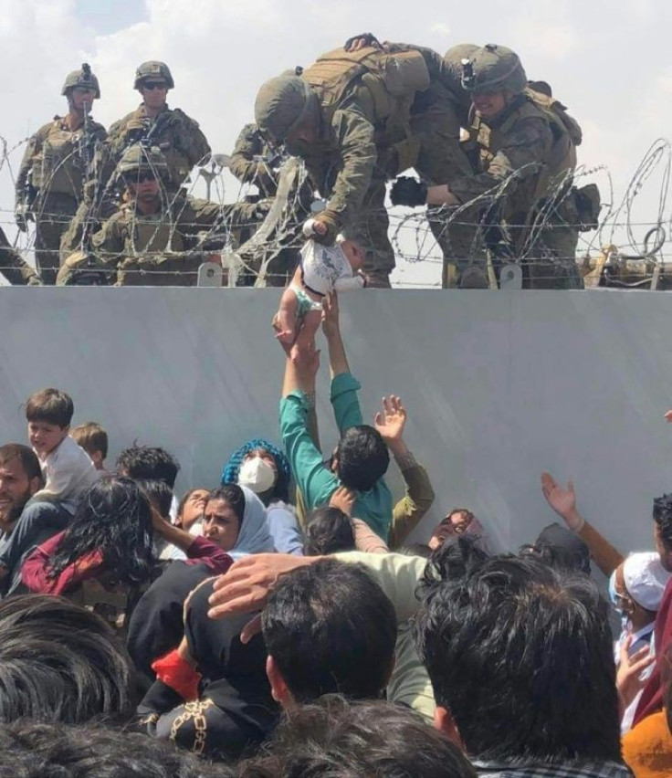 Footage of an Afghan child being handed off to a US Marine over a wire-topped wall at Kabul's airport went viral on social media