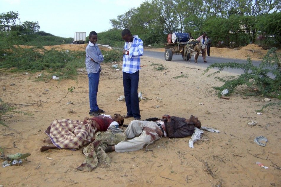 Civilians look at the suspected body of Fazul Abdullah and an unidentified colleague killed at a police checkpoint in Somalia039s capital Mogadishu
