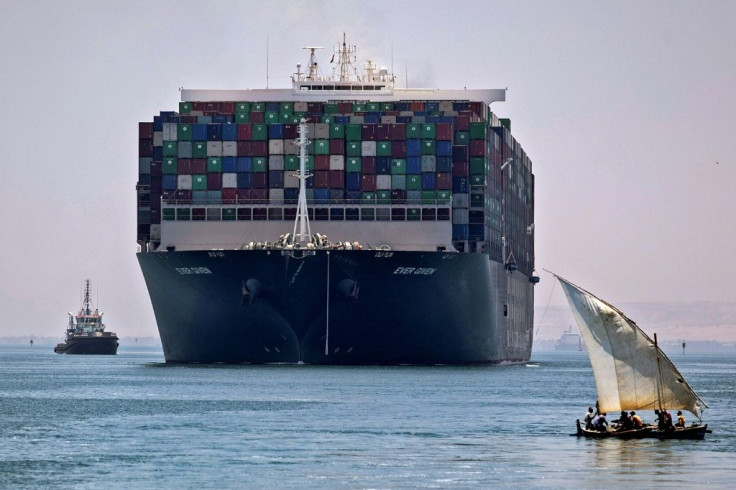 A file picture taken on July 7, 2021 shows the MV Ever Given container ship sailing near a felucca along Egypt's Suez Canal near the canal's central city of Ismailia, as it departs from the waterway