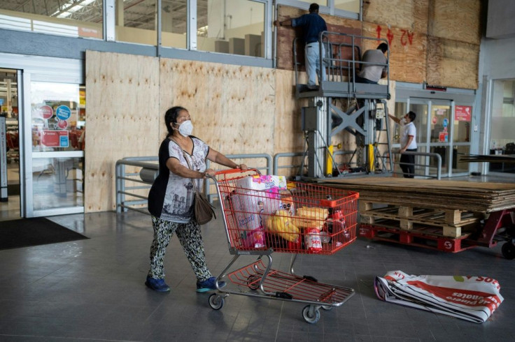 Workers board up windows of a supermarket in Mexico's eastern state of Veracruz to prevent damage from approaching Hurricane Grace