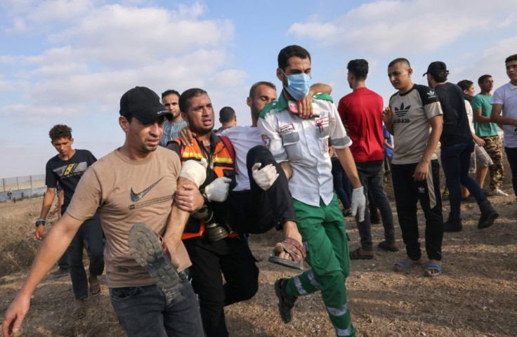 Palestinian medics and protesters evacuate an injured man hurt in clashes with Israeli security forces on Saturday