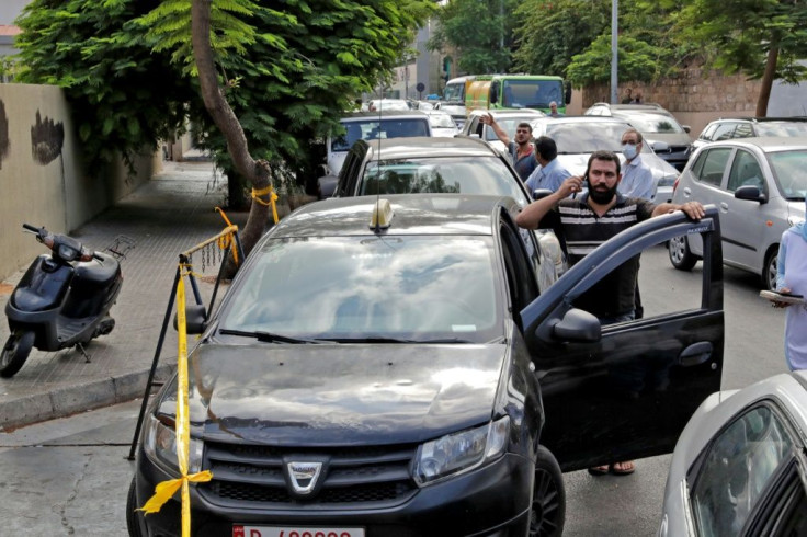 Lebanese wait in a queue outside a closed petrol station in Beirut's Hamra district in this file picture taken on August 20, 2021