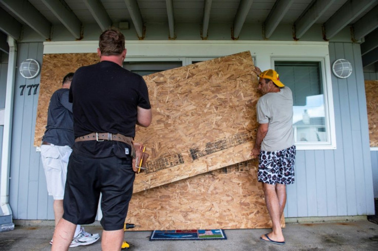 Members of the Edelweiss construction crew worked fast to protect costal homes by barricading their windows and doors with plywood sheets before Hurricane Henri hits the beach front area in New London, Connecticut