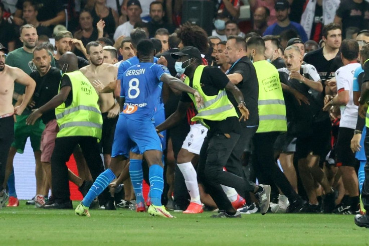 Flash point: Security try to hold back fans as they invade the pitch at Nice's Allianz Riviera Stadium