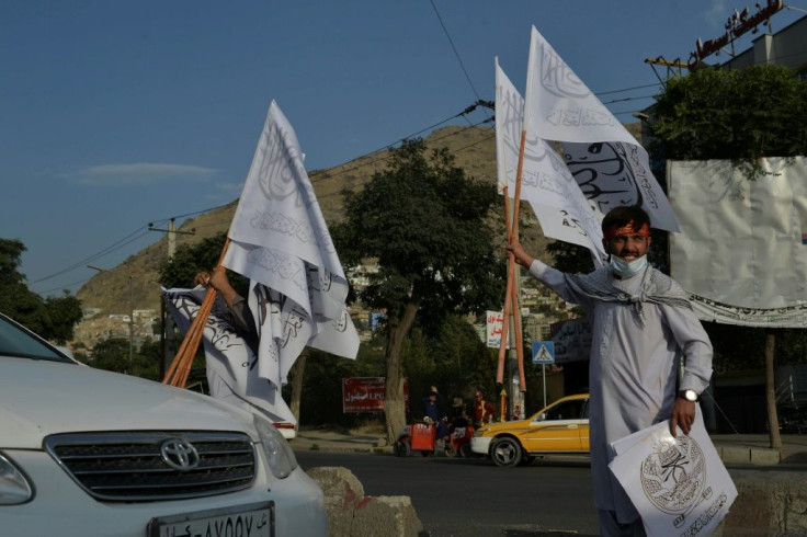Taliban flags being sold on Sunday in Kabul, where streets are quiet since the militants' takeover -- except for around the airport as tens of thousands try to flee