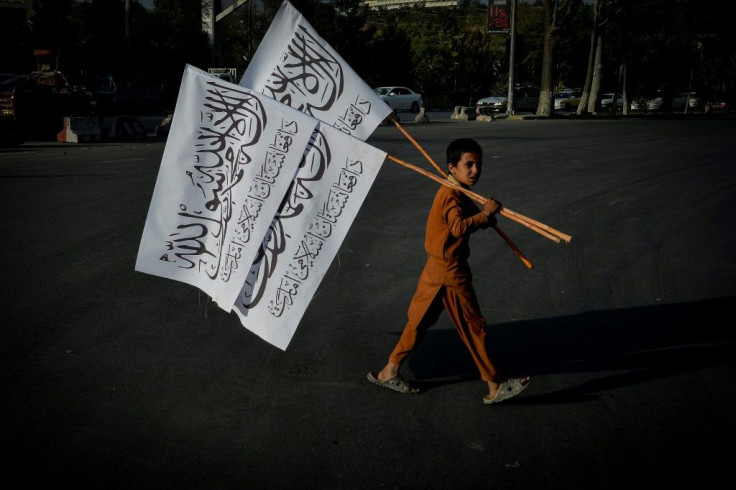 A boy carries Taliban flags to sell in the Afghan capital Kabul