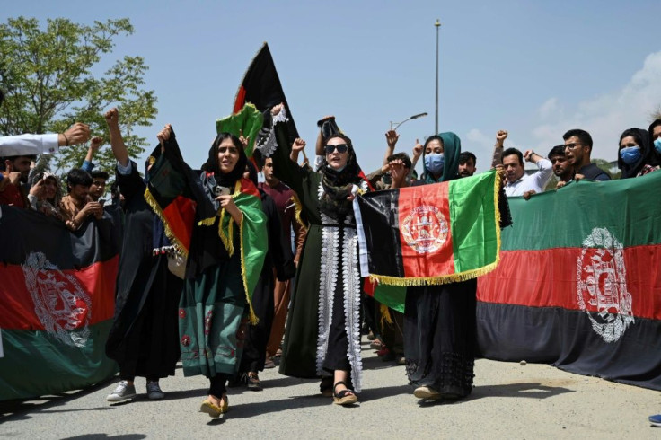 Afghans hold national tri-colour flags as they celebrate Independence Day in Kabul, days after the Taliban takeover