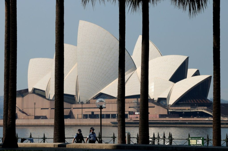 Police officers patrol in front of the Sydney Opera House as the city extends its two-month-old Covid lockdown