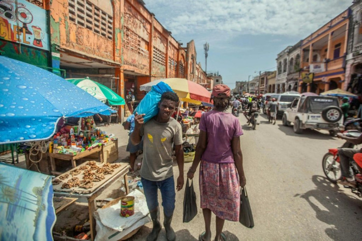 People walk down a street after the August 14 earthquake in Les Cayes, Haiti, on August 23, 2021