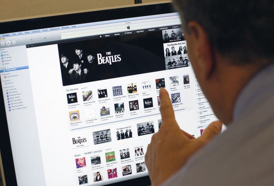 A man poses as he looks at music from the legendary band The Beatles on Apples itunes music store website 