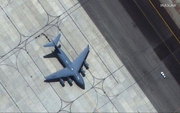 People prepare to load on C-17 transport aircraft on the tarmac at Kabulâs Hamid Karzai International Airport on August 23, 2021