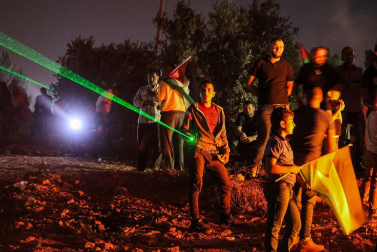 Palestinian protesters in Beita use laser pointers during a demonstration against the Israeli settler outpost of Eviatar on July 1, 2021