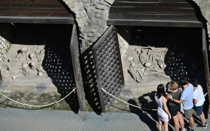 Visitors view human skeletons at the archaeological site of Herculaneum in Ercolano, near Naples