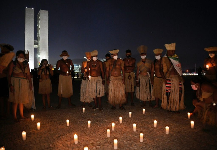 Members of different indigenous tribes hold a candlelit vigil outside the Supreme Court Building in Brasilia, on August 24, 2021